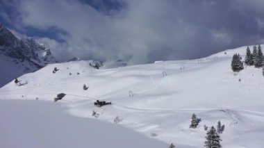 Flight over snow-capped mountains in the Swiss Alps on a winters day - aerial footage
