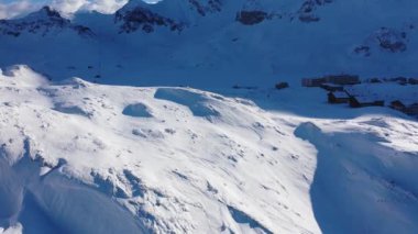Flight over snow-capped mountains in the Swiss Alps on a winters day - aerial footage