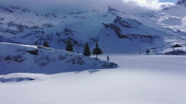 Alplerdeki kış gölü karla kaplıydı. İnsansız hava aracı görüntüleri.  