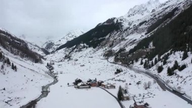 Flight over snow-capped mountains in the Swiss Alps on a winters day - aerial footage