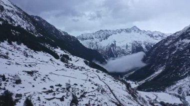 Flight over snow-capped mountains in the Swiss Alps on a winters day - aerial footage