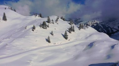 Flight over snow-capped mountains in the Swiss Alps on a winters day - aerial photography