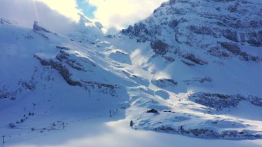 Flight over snow-capped mountains in the Swiss Alps on a winters day - aerial photography