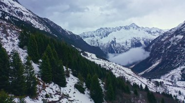 Flight over snow-capped mountains in the Swiss Alps on a winters day - aerial photography