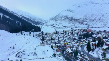 Flight over the famous village of Andermatt in Switzerland in winter - aerial photography