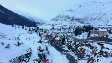 Flight over snow-capped mountains in the Swiss Alps on a winters day - aerial photography