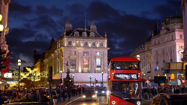 Red bus in London at Piccadilly Circus evening view - LONDON, ENGLAND - DECEMBER 10, 2019 — 스톡 사진