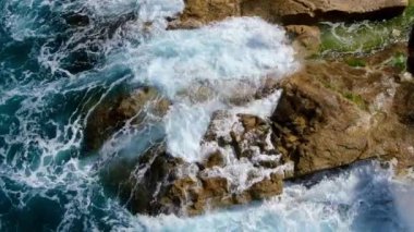 Yukarıdan gelen vahşi okyanus suyu - kayalara vuran dalgalar - hava görüntüleri