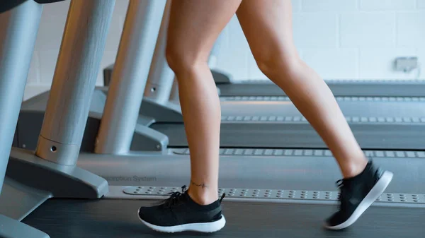 Dziewczyna biegnie na bieżni w siłowni — Zdjęcie stockowe