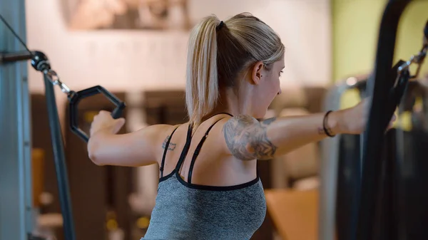 Спортивная и сексуальная девушка делает упражнения в тренажерном зале для фитнеса — стоковое фото