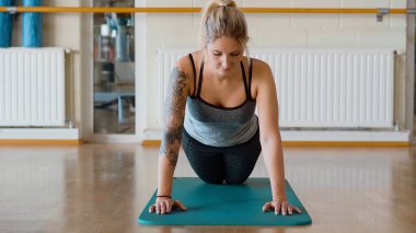 Spor salonunda şınav çeken genç bir kız.