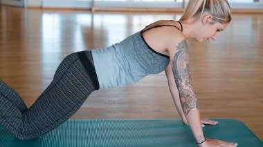 Spor salonunda şınav çeken genç bir kız.