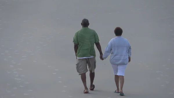 Para staruszków spacerujących po plaży - DAYTONA BEACH, USA 14 kwietnia 2016 - zdjęcia z wakacji — Zdjęcie stockowe