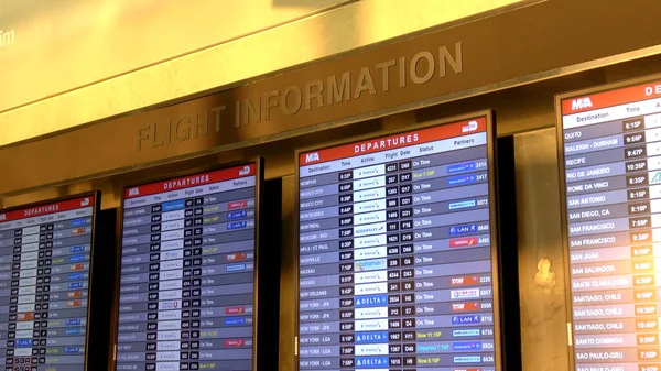 Pantalla de salidas y llegadas en el aeropuerto de Miami - MIAMI, EE.UU. 10 DE ABRIL DE 2016 — Foto de Stock