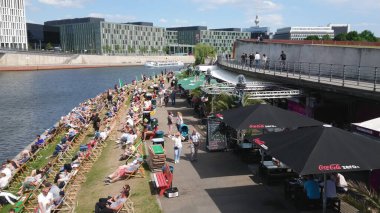 Sıcak bir yaz gününde Berlin 'deki River Spree' de popüler plaj kulübü BERLIN, Almanya - 21 Mayıs 2018