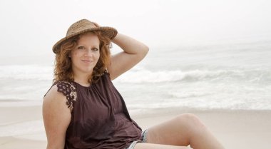 Güzel kız okyanus kıyısındaki sahilde eğleniyor. Yaz tatili.