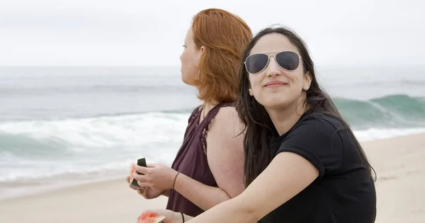 Due ragazze mangiano un'anguria in spiaggia — Foto Stock