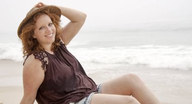 Genç kadın yaz tatili boyunca plajda dinleniyor.