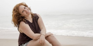 Güzel kız okyanus kıyısındaki sahilde eğleniyor. Yaz tatili.