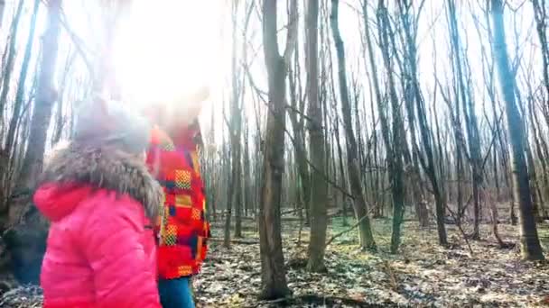 Mor med dotter går genom skogen våren i soliga strålar — Stockvideo