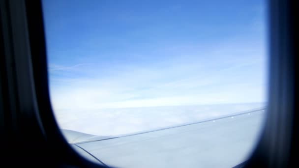 飛行機の窓からの眺め。空、雲、飛行機の翼を見ることができます。天気がよければ、それは晴れた日 — ストック動画