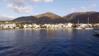 Sabah Yunan boş Marina, metan. Hava video çekim. Boş bir iskele. Arka planda dağlar ve şehir evleri manzara var. Yaz Açık sabah, mavi gökyüzü bulutlu