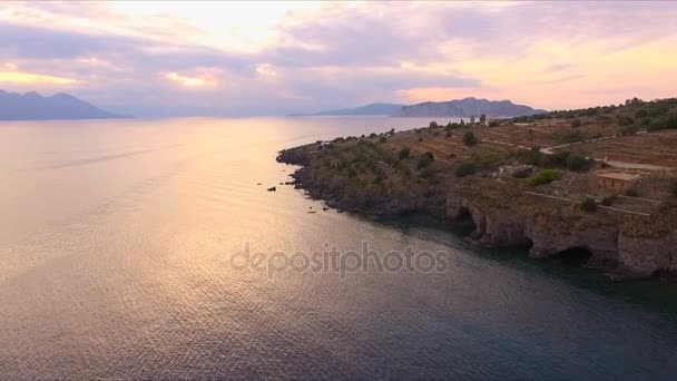 Tramonto nella baia vuota del Mar Mediterraneo, vicino all'isola greca. La superficie dell'acqua splende al sole, il cielo, limpido, le montagne sono visibili da una vista a volo d'uccello. Video aeronautico — Video Stock