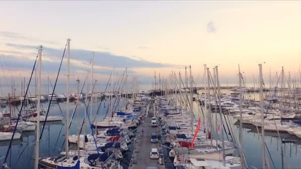 アテネ、ギリシャのマリーナの夜明け。エアロのビデオ撮影します。異なるヨット、カタマランの多くは、桟橋に係留。背景には、海、青い空の風景です。夏の明確な朝、穏やかです — ストック動画