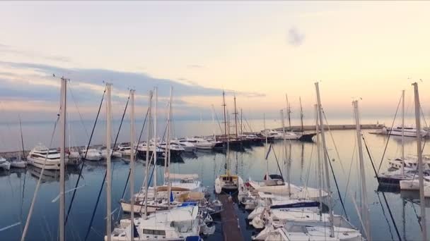 Aube dans la marina grecque, Athènes. Tournage vidéo Aero. Beaucoup de yachts différents, catamarans amarrés aux jetées. En arrière-plan se trouve le paysage de la mer, ciel bleu. Matin clair d'été, calme — Video