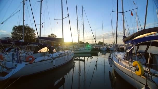 Un sacco di belle barche a vela e catamarani ormeggiati al molo nel porto turistico greco di Atene, nel Mediterraneo, una chiara mattina d'estate, alba. Alti alberi di yacht. Vista dal molo — Video Stock