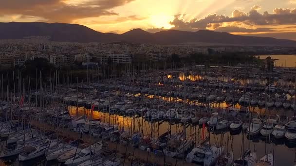 Amanecer en el puerto deportivo griego, Atenas. Grabación de video Aero. Muchos yates diferentes, catamaranes amarrados a muelles. En el fondo se encuentra el paisaje de las montañas y las casas de la ciudad. Verano claro — Vídeos de Stock