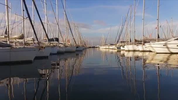 A lot of beautiful sailing yachts and catamarans moored to the pier in the Greek marina in Athens, the Mediterranean, a clear summer morning, sunrise. High masts of yachts. View from the pier — Stock Video