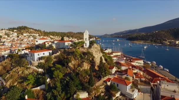 Liggande grekiska ön Poros mitt i Medelhavet med ett fågelperspektiv, antenn video skjutning, många förtöjd till piren, segelbåtar, katamaraner, sundet mellan öarna, en — Stockvideo