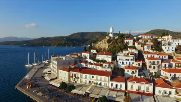 Landscape Greek island of Poros amidst the Mediterranean, with a birds-eye view, aerial video shooting, many moored to the pier, sailing yachts, catamarans, the strait between the islands, a — Stock Video