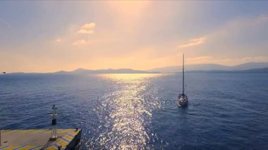 Boş bir Yunan Marina, Methana, Akdeniz gün batımı. Aero video çekim, yalnız yelkenli yat marina gelir. Arka plan, deniz, açık mavi gökyüzü, bir güneşli bir manzara