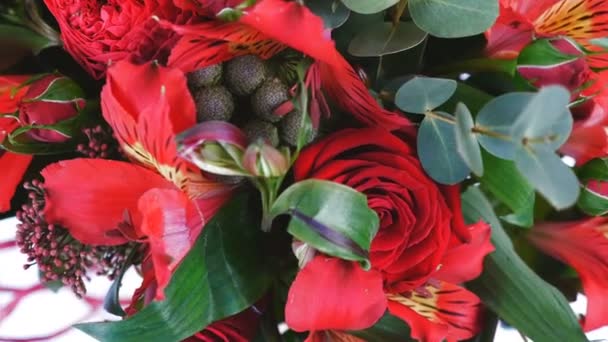 Θέα από ψηλά, γκρο πλαν. Λουλούδια, μπουκέτο, περιστροφή, φλοράλ σύνθεση αποτελείται από Αλστρομέριες, prestige τριαντάφυλλο, πράσινο Brunia, σολιντάγκο, ευκάλυπτος, πιόνιο σχήμα τριαντάφυλλου Μπορντό — Αρχείο Βίντεο