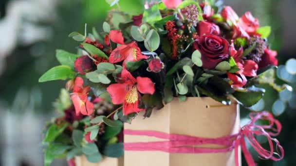 Μπουκέτο λουλουδιών στις ακτίνες του φωτός, περιστροφή, φλοράλ σύνθεση αποτελείται από Αλστρομέριες, τριαντάφυλλο prestige, πράσινο Brunia, σολιντάγκο, ευκάλυπτος, Μπορντό πιόνιο σε σχήμα τριαντάφυλλο — Αρχείο Βίντεο