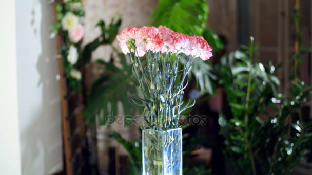Kytice v paprscích světla, rotace, květinová kompozice se skládá ze světle růžové turecké karafiát v pozadí hodně zeleně