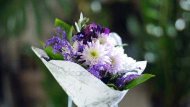 Işık, döndürme, ışınları içinde çiçek buketi kompozisyon oluşur krizantem papatya, solidago, Alstroemeria, Russus. Arka planda bir sürü yeşillik