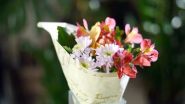 Işık, döndürme, çiçek kompozisyon ışınları içinde çiçek buketi Cymbidium orkide, Alstroemeria, krizantem oluşur. Arka planda bir sürü yeşillik