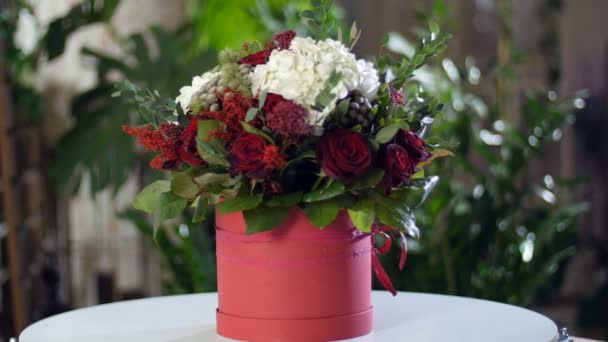 Ramo de flores en los rayos de luz, rotación, composición se compone de hortensias, rosa, verde de Brunia, eucalipto, Eustoma, solidago. En el fondo un montón de vegetación — Vídeos de Stock