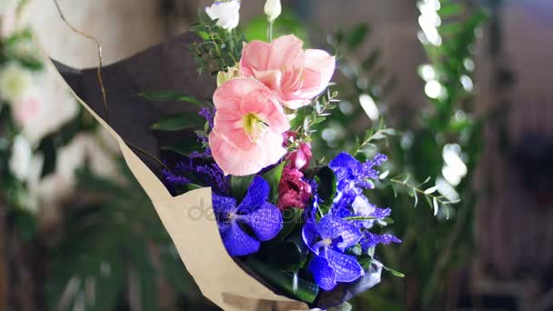 Ramo de flores en los rayos de luz, rotación, composición consta de Eustoma, eucalipto, Amarilis rosa, vanda orquídea, piano tulipán, solidago. en el fondo un montón de vegetación — Vídeos de Stock