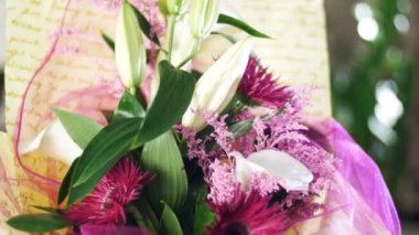 yakın çekim, çiçek buketi ışınları ışık, döndürme, çiçek kompozisyon içinde solidago calla oluşur, lily, Gerbera terry Russus. arka planda bir sürü yeşillik
