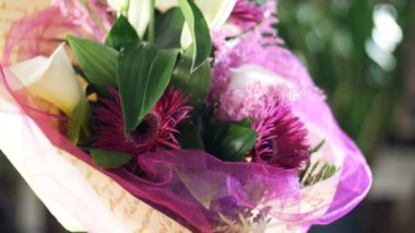 yakın çekim, çiçek buketi ışınları ışık, döndürme, çiçek kompozisyon içinde solidago calla oluşur, lily, Gerbera terry Russus. arka planda bir sürü yeşillik