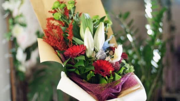 Buquê de flores nos raios de luz, rotação, a composição floral consiste em Santini, solidago, lírio, gerbera, Barbatus, Russus.in fundo um monte de vegetação — Vídeo de Stock