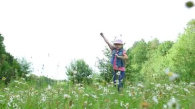 Çim, çayırda, dans, Zıplama, eğlenceli, güzel bir kız, yaklaşık yedi yaşında sahip papatyalar arasında. Uzun sarı saçlı, kot yelek ve pembe şapka giymiş