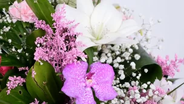 Gros plan, Fleurs, bouquet, rotation sur fond blanc, composition florale composée de Phoenix robbeli, eucalyptus, Chrysanthème, Lydie rose, Oeillet, gypsophila, solidago , — Video