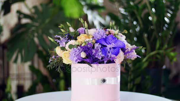 Bouquet de fleurs dans les rayons de lumière, rotation, la composition florale se compose de vanda d'orchidée, solidago, oeillet, Hiperikum, Rose en forme de pion, Eustoma, solidago, eucalyptus 