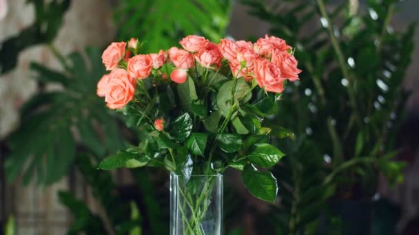 Ramo de flores en los rayos de luz, rotación, la composición floral consta de rosas de color naranja. Belleza divina. en el fondo un montón de vegetación . — Vídeo de stock
