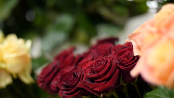 Primer plano, Floristería, en el escaparate hay un montón de ramos de flores con diferentes rosas de colores . — Vídeos de Stock